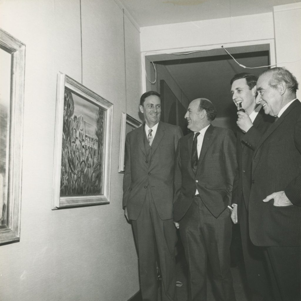 Gray Smith and Arthur Wicks standing with two other men at their 1968 exhibition at the Cité Internationale des Arts in Paris. Arthur is holding a pipe.