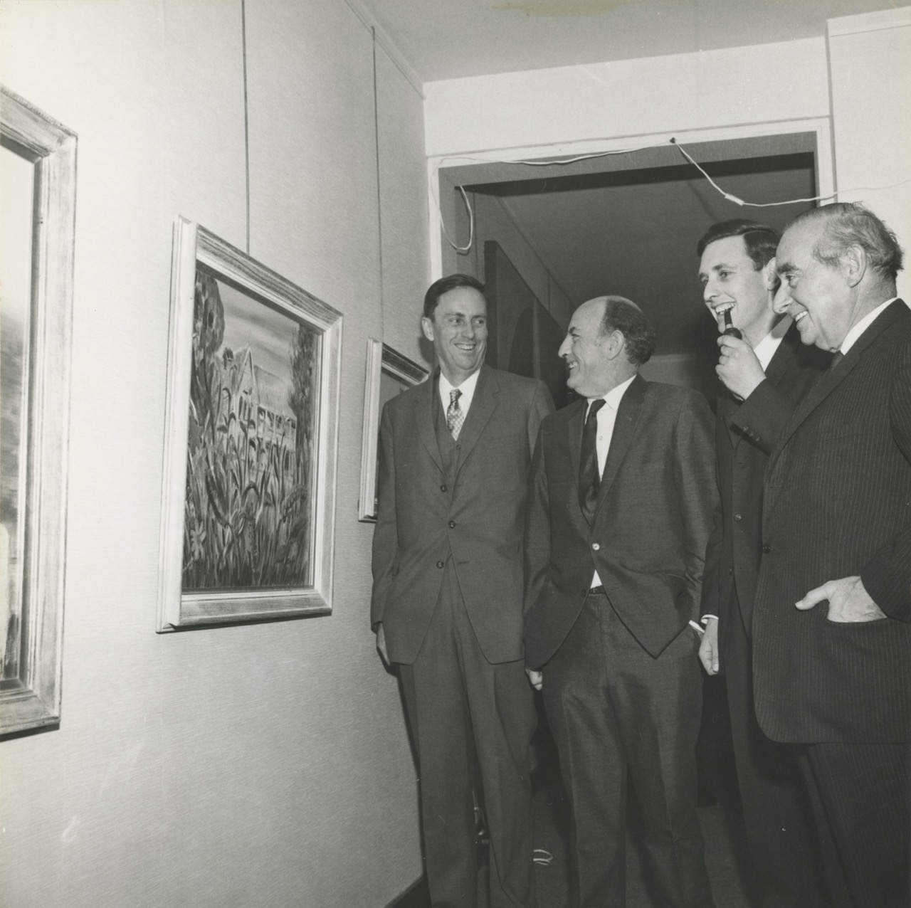 Gray Smith and Arthur Wicks standing with two other men at their 1968 exhibition at the Cité Internationale des Arts in Paris. Arthur is holding a pipe.