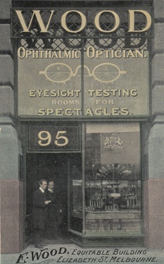 Shopfront of E. Wood & Sons, Ophthalmic Optician at 95 Elizabeth Street, Melbourne, shown on a historical postcard.